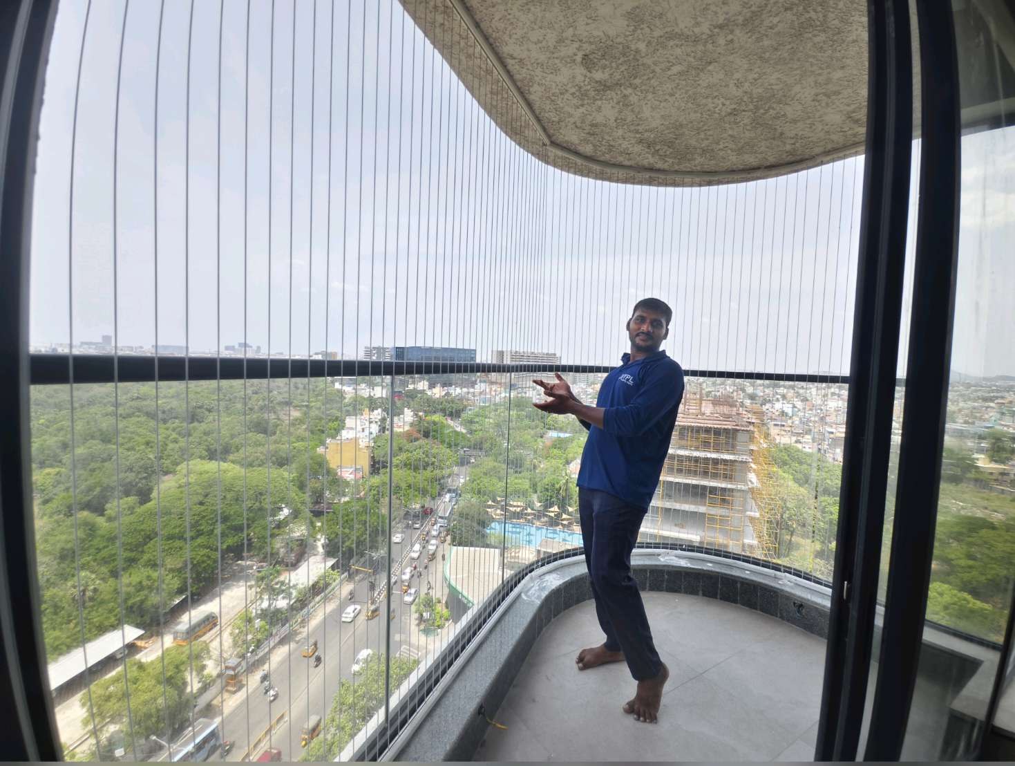 Installer adjusting cables on a curved balcony — real YPL work shown for Saligramam customers
