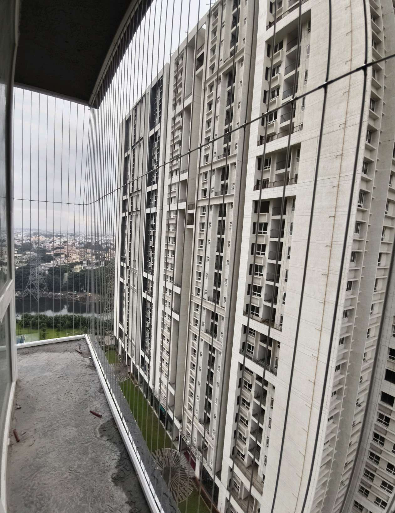 Narrow high-rise balcony fitted with protective cables — real YPL work shown for Vyasarpadi customers