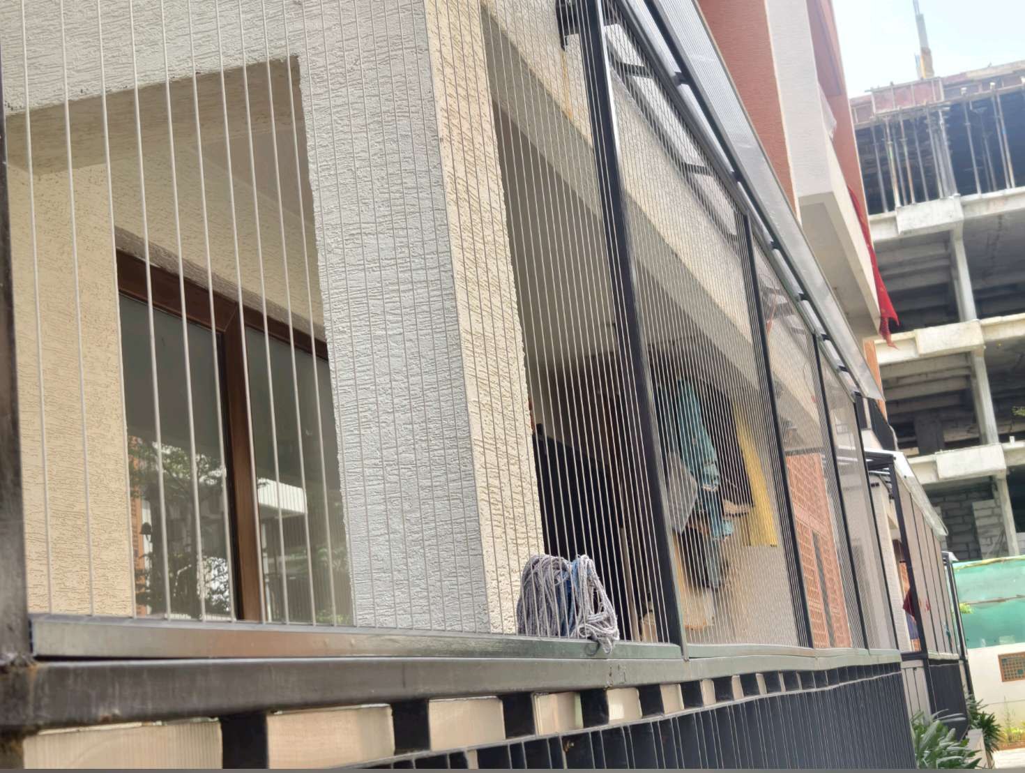Building exterior with fine vertical grill cables — real YPL work shown for Padappai customers