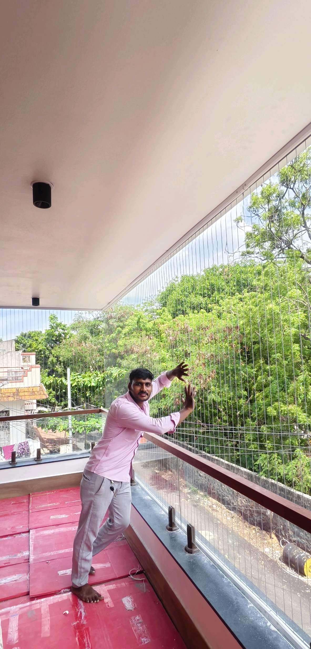 Worker fitting cables on a balcony with a garden view — real YPL work shown for Padur customers