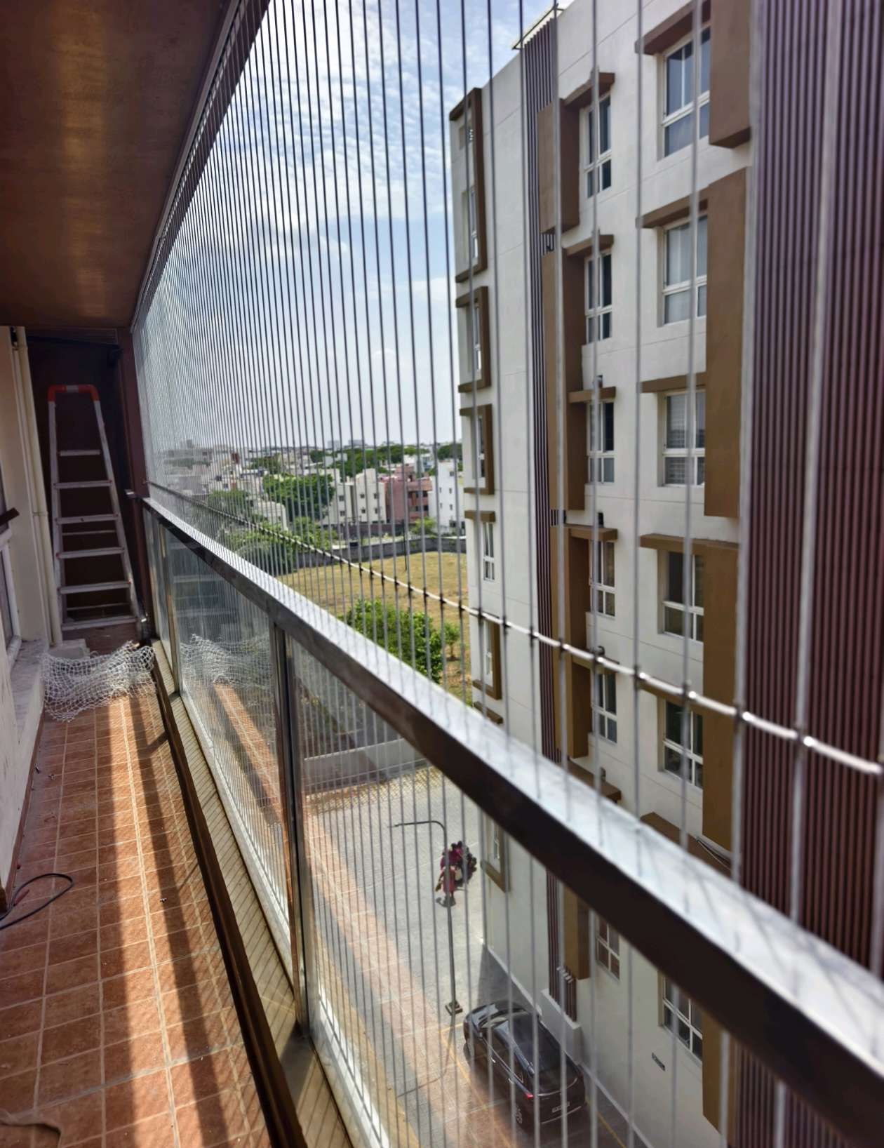 Long apartment balcony protected with invisible grill cables — real YPL work shown for Kottivakkam customers