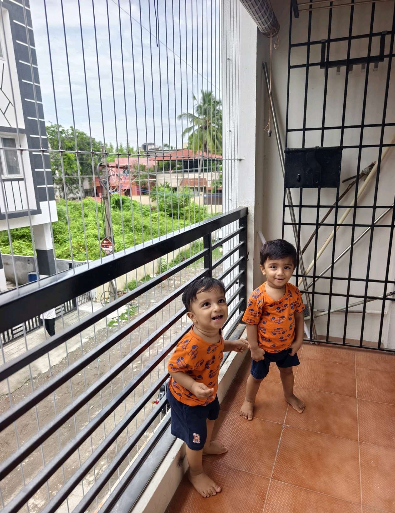 Two children standing behind a protected balcony railing — real YPL work shown for Ullagaram customers