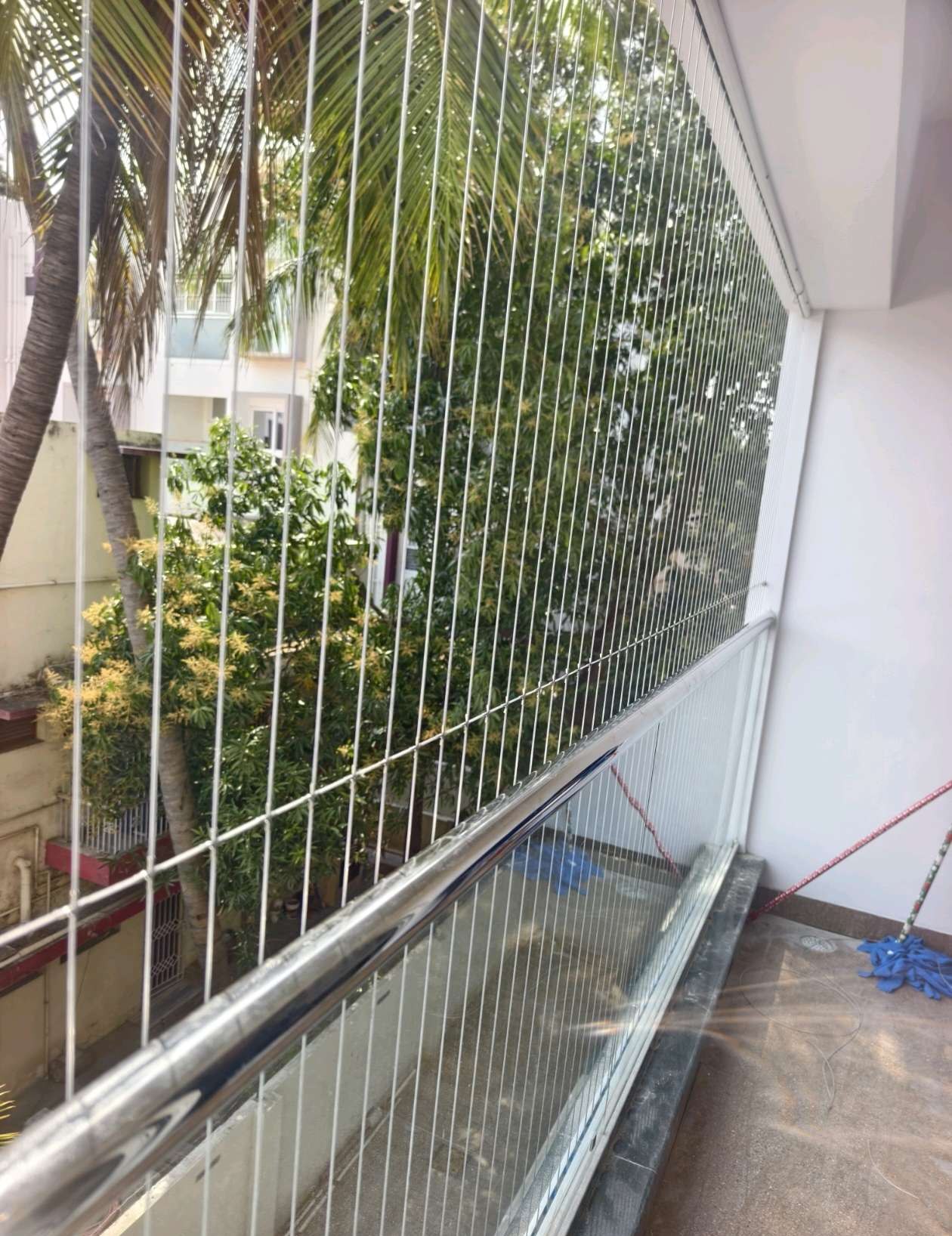 Narrow balcony with a railing and fine protective cables — real YPL work shown for Ennaikaran customers