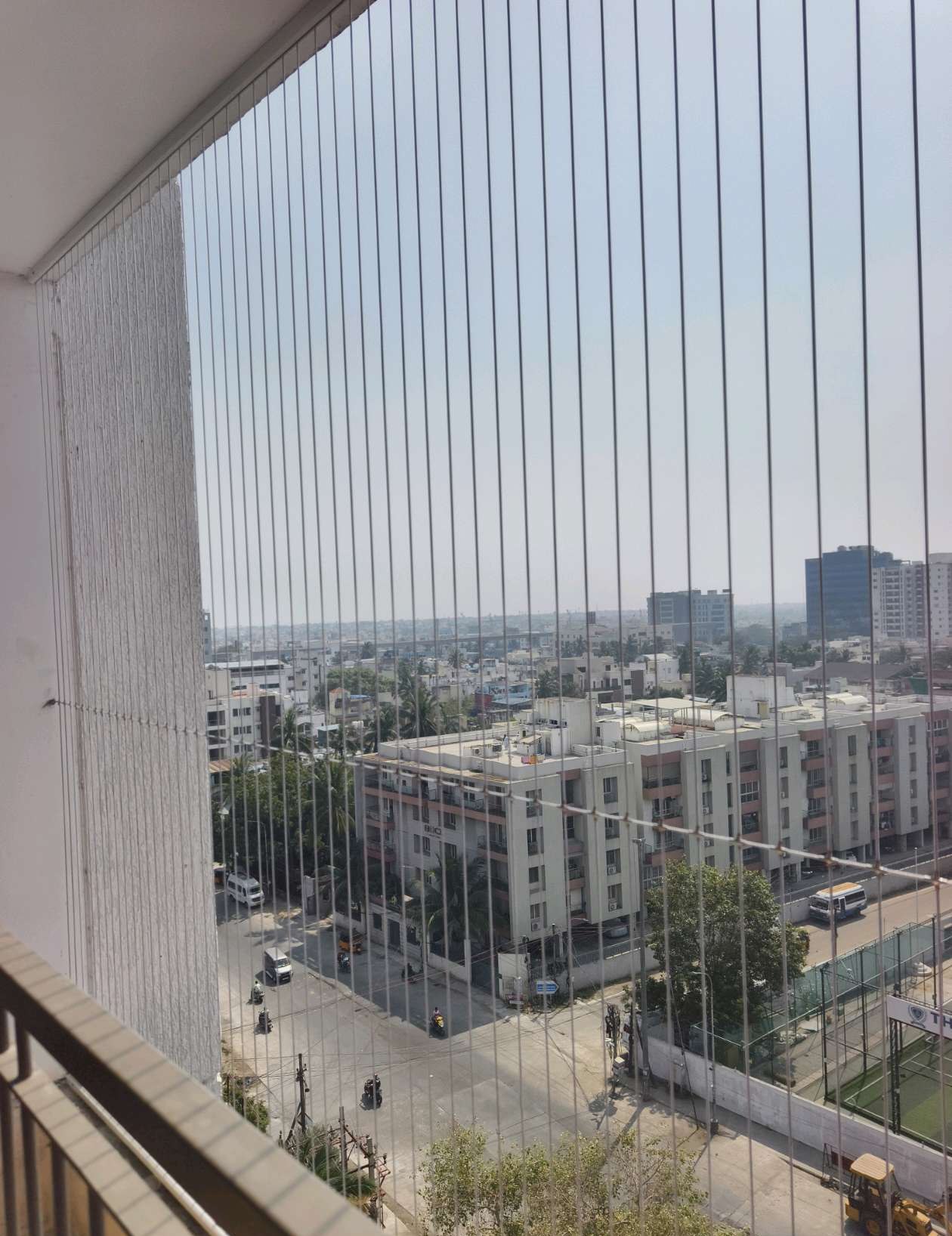 High-rise balcony protected by vertical grill cables — real YPL work shown for Ennore customers