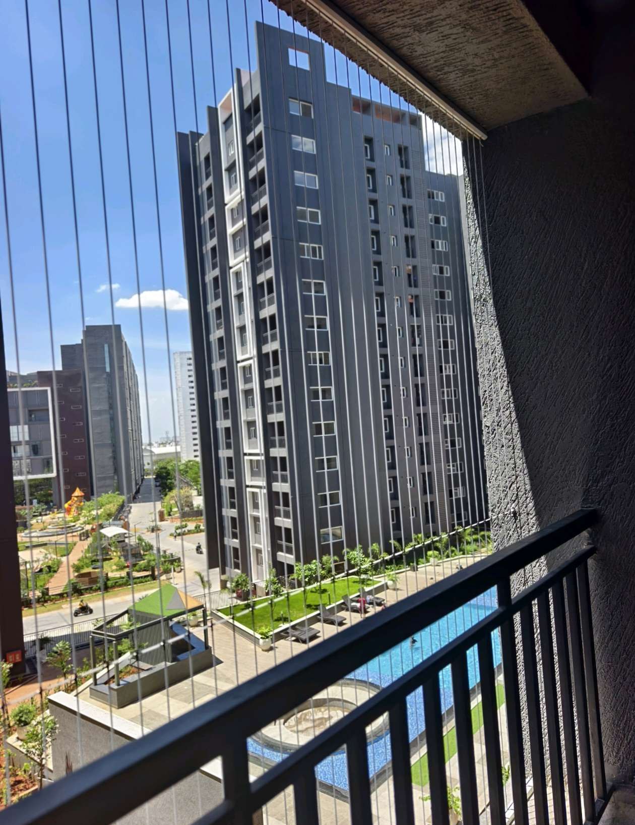 High-rise balcony with city-facing railing and grill cables — real YPL work shown for Puzhal customers