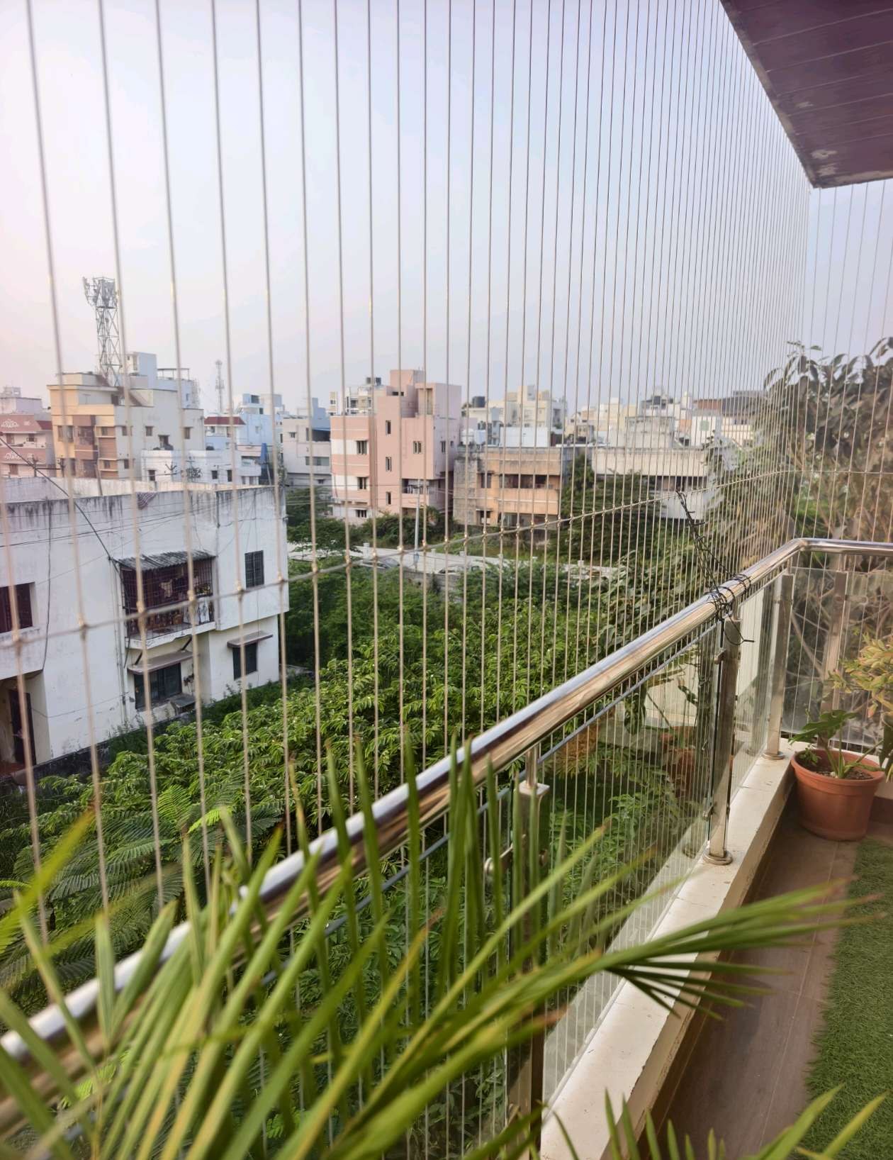 City-facing balcony with horizontal protective cables — real YPL work shown for Gopalapuram customers
