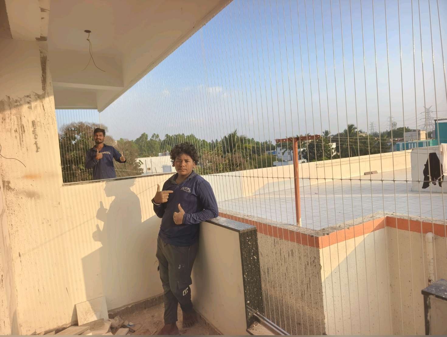 Installer beside a terrace railing and fine cables — real YPL work shown for Saligramam customers