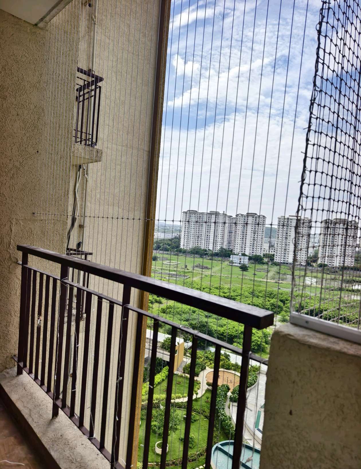 Balcony corner with vertical cables and a neighborhood view — real YPL work shown for Sadras customers