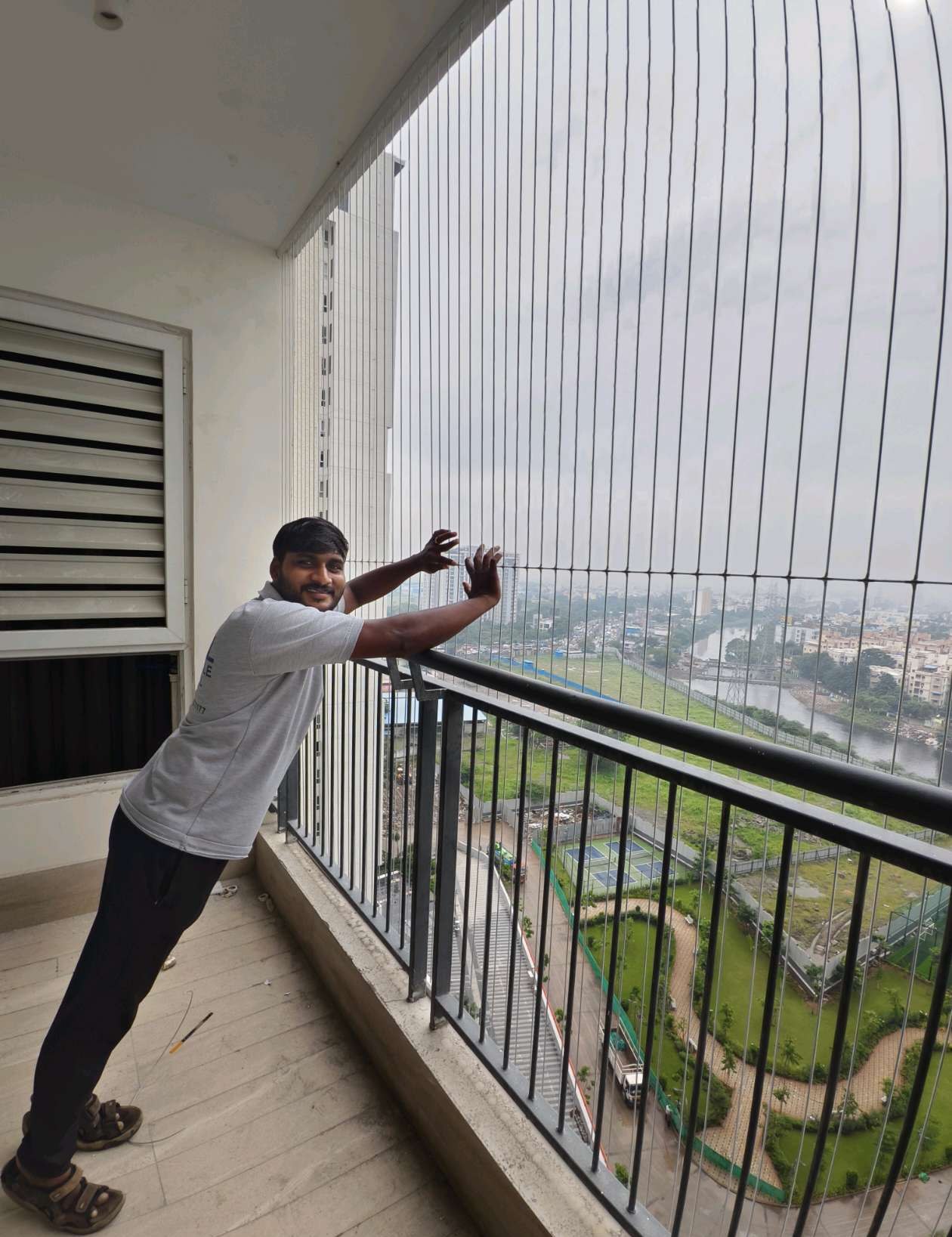 Installer adjusting cables on a high-rise balcony — real YPL work shown for Rajakilpakkam customers