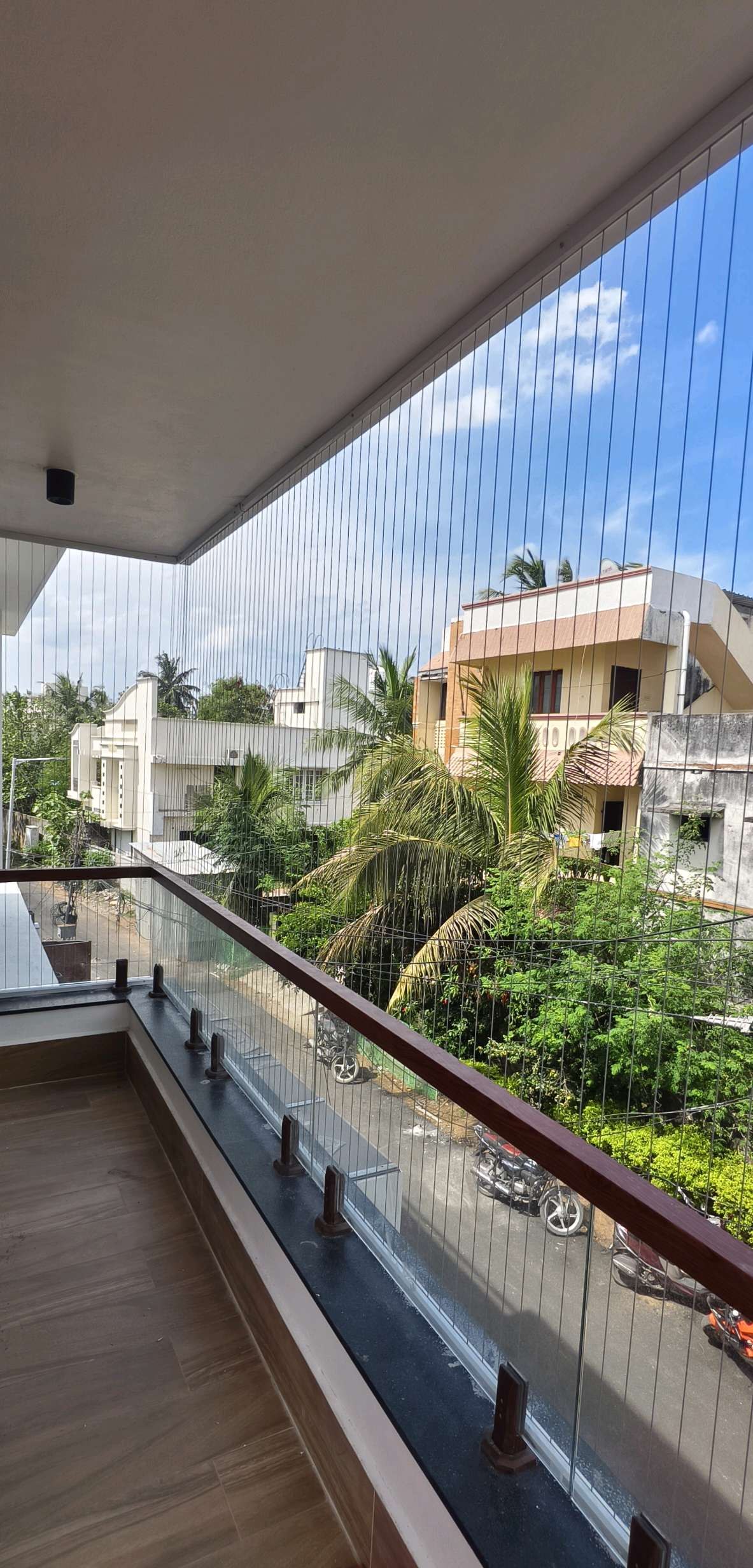 Narrow balcony with protective cables and trees outside — real YPL work shown for Paranur customers