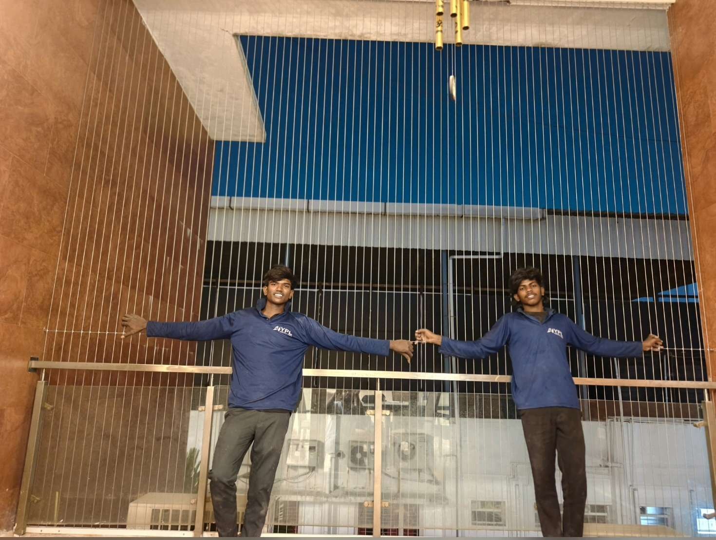 Two workers fitting grill cables along a balcony — real YPL work shown for Kottivakkam customers