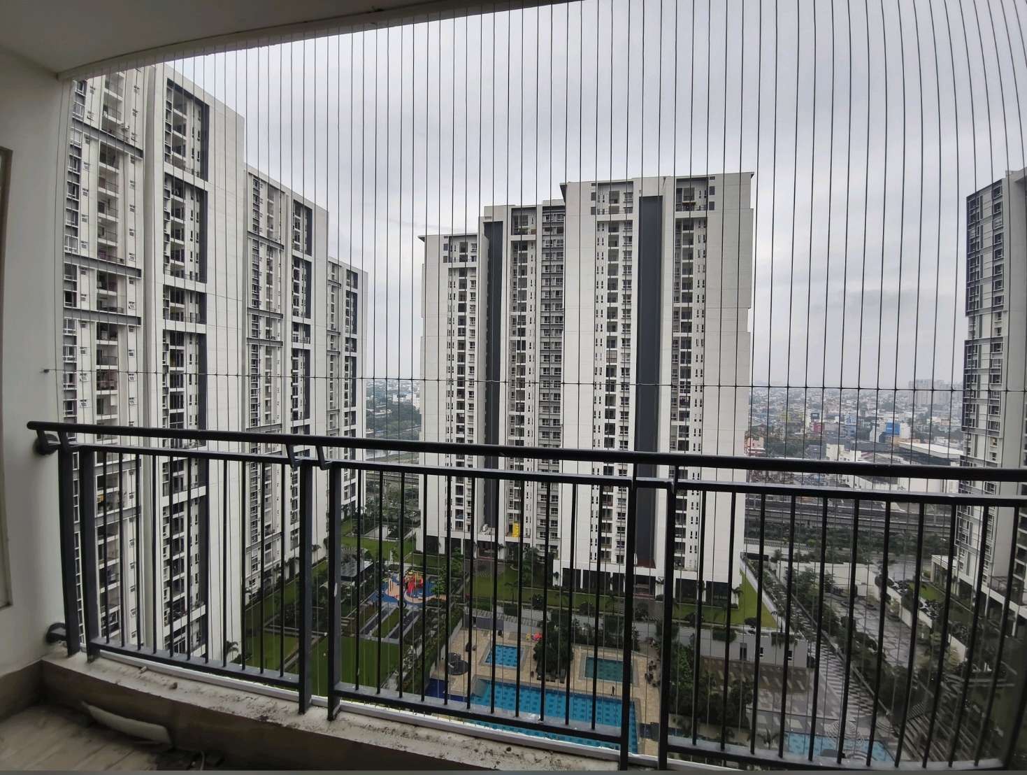 Apartment balcony with grill cables and neighboring towers — real YPL work shown for Akkarai customers