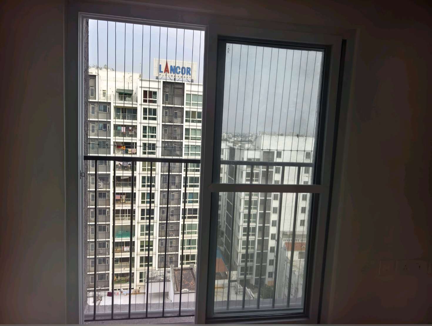 Sliding balcony doors with vertical grill cables beyond — real YPL work shown for Rajakilpakkam customers