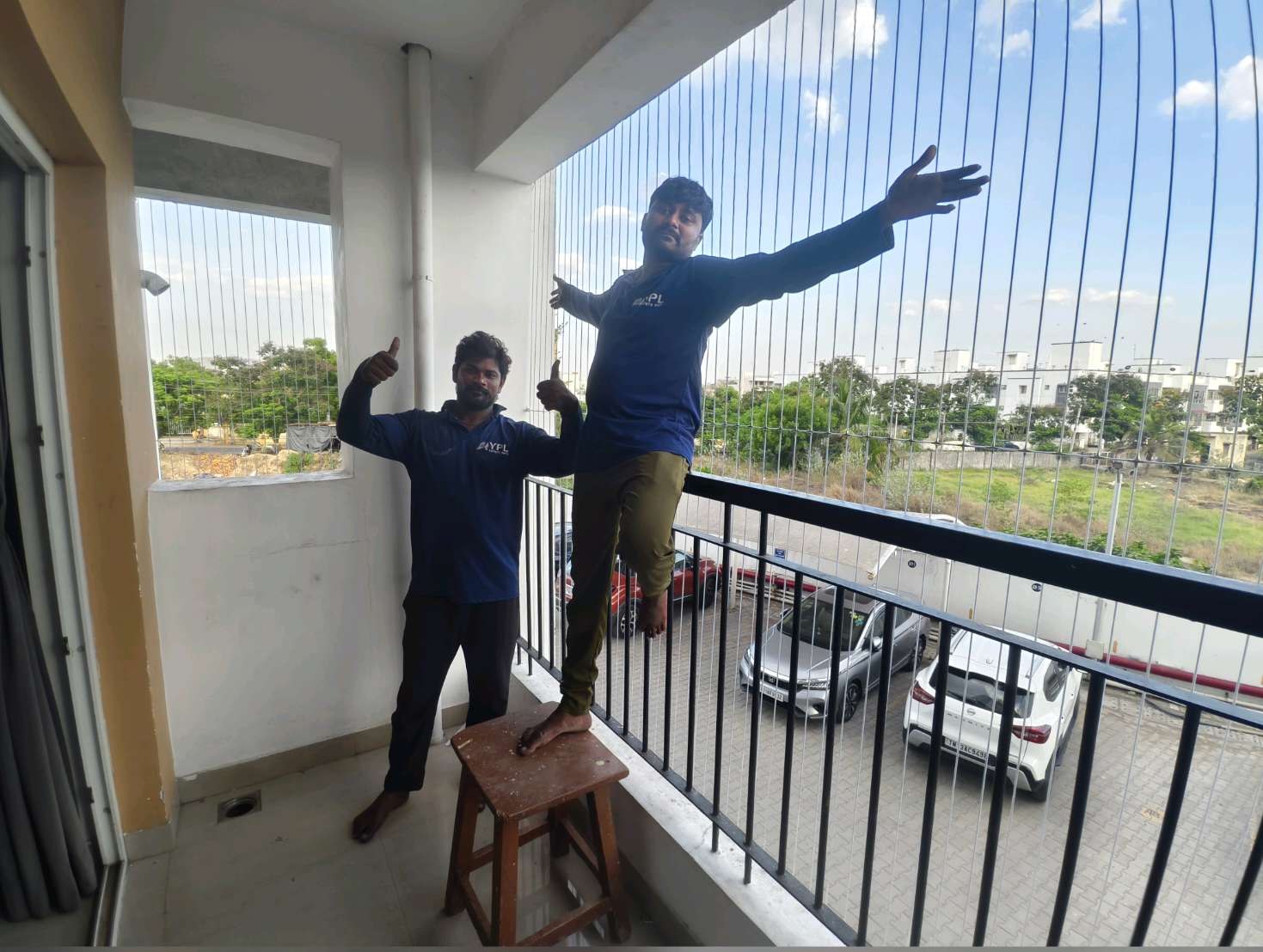 Installers working on a balcony with a green view — real YPL work shown for Melmaruvathur customers