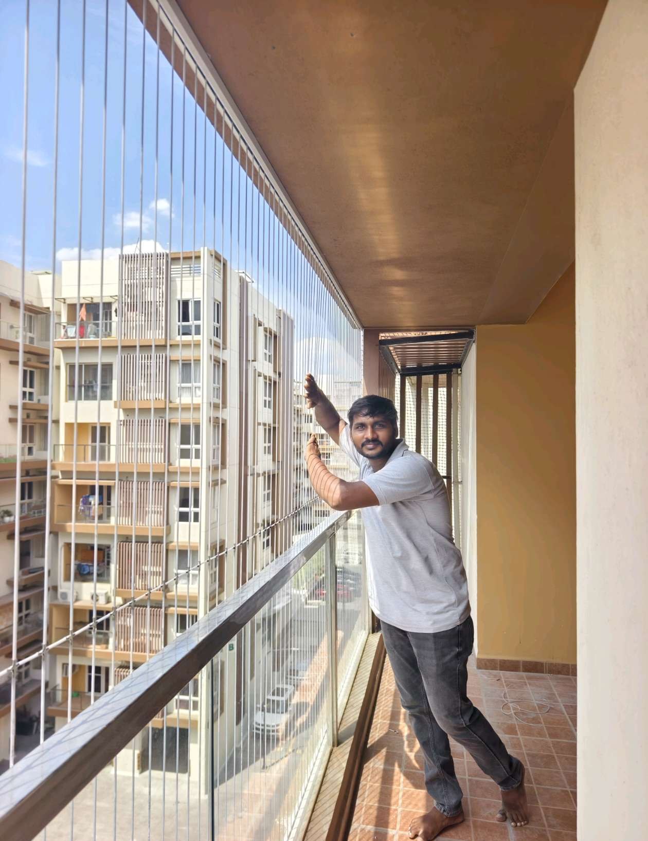 Installer fitting cables along an apartment balcony — real YPL work shown for Kolathur customers