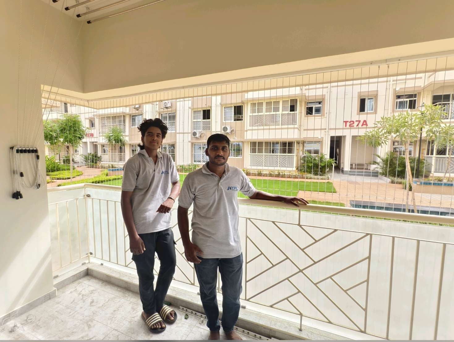 Two installers beside a wide residential balcony — real YPL work shown for Melmaruvathur customers
