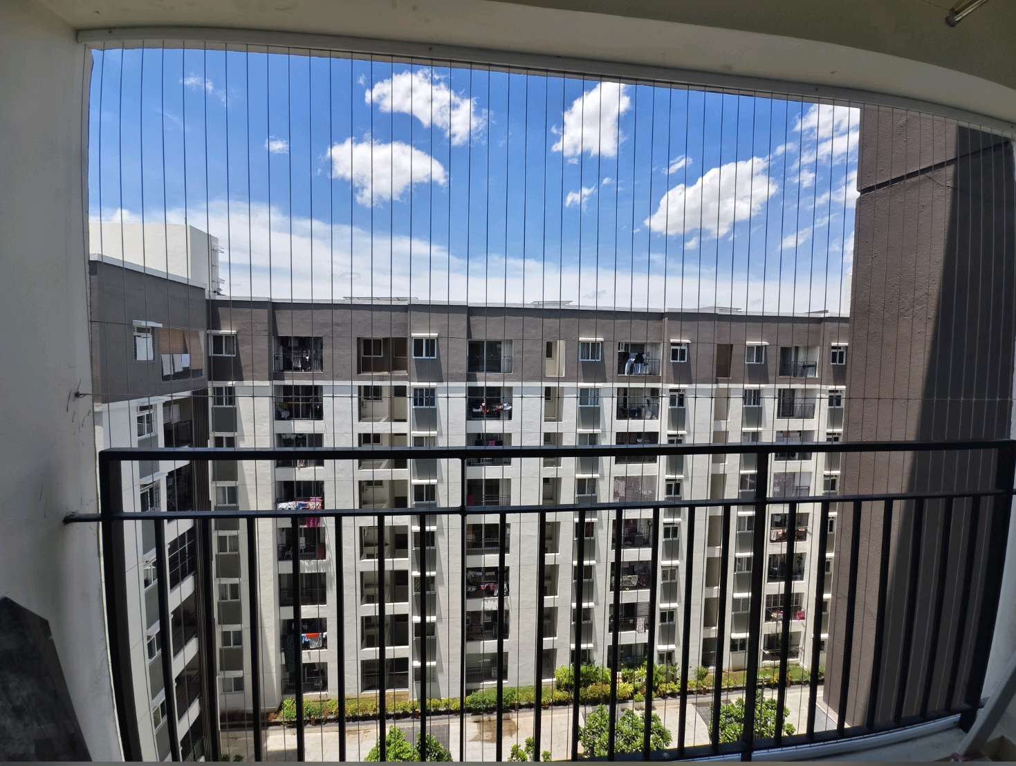 Broad high-rise balcony opening fitted with vertical grill cables — real YPL work shown for Paranur customers