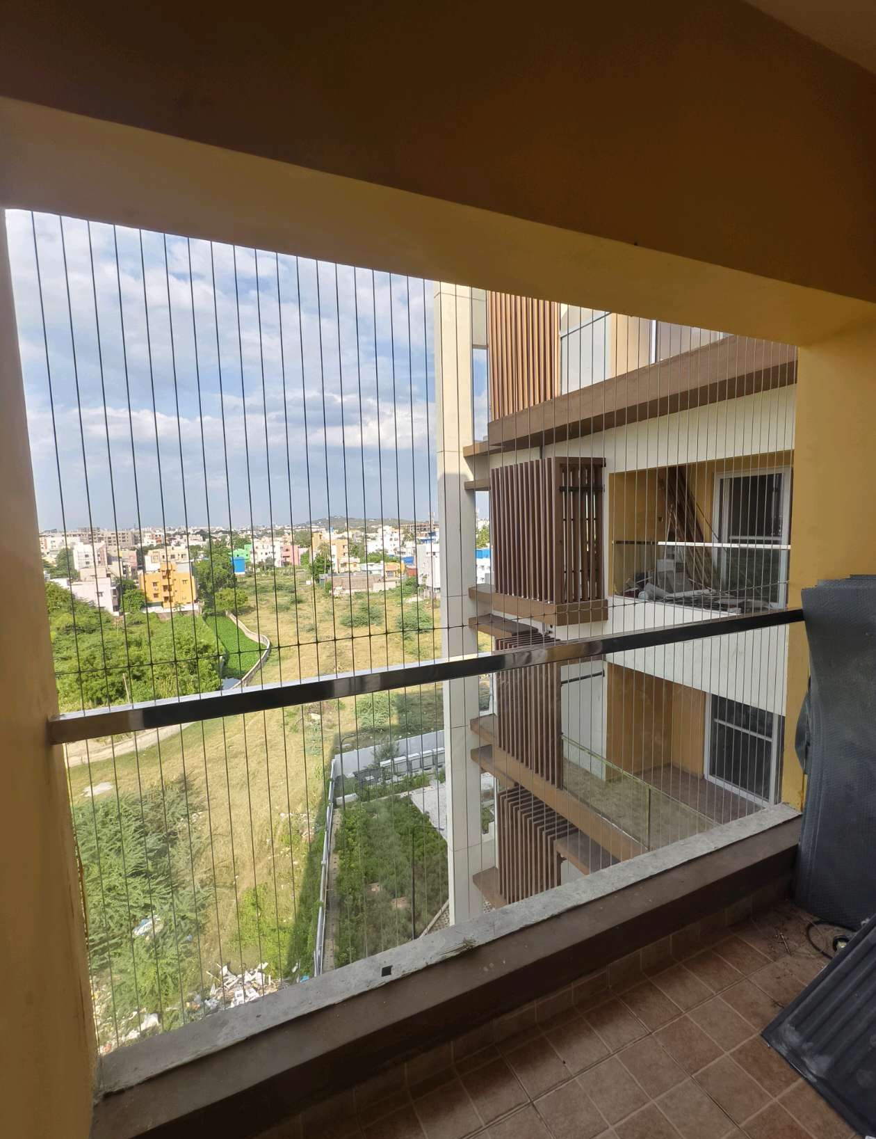 Window with a balcony view behind fine cables — real YPL work shown for Perungalathur customers