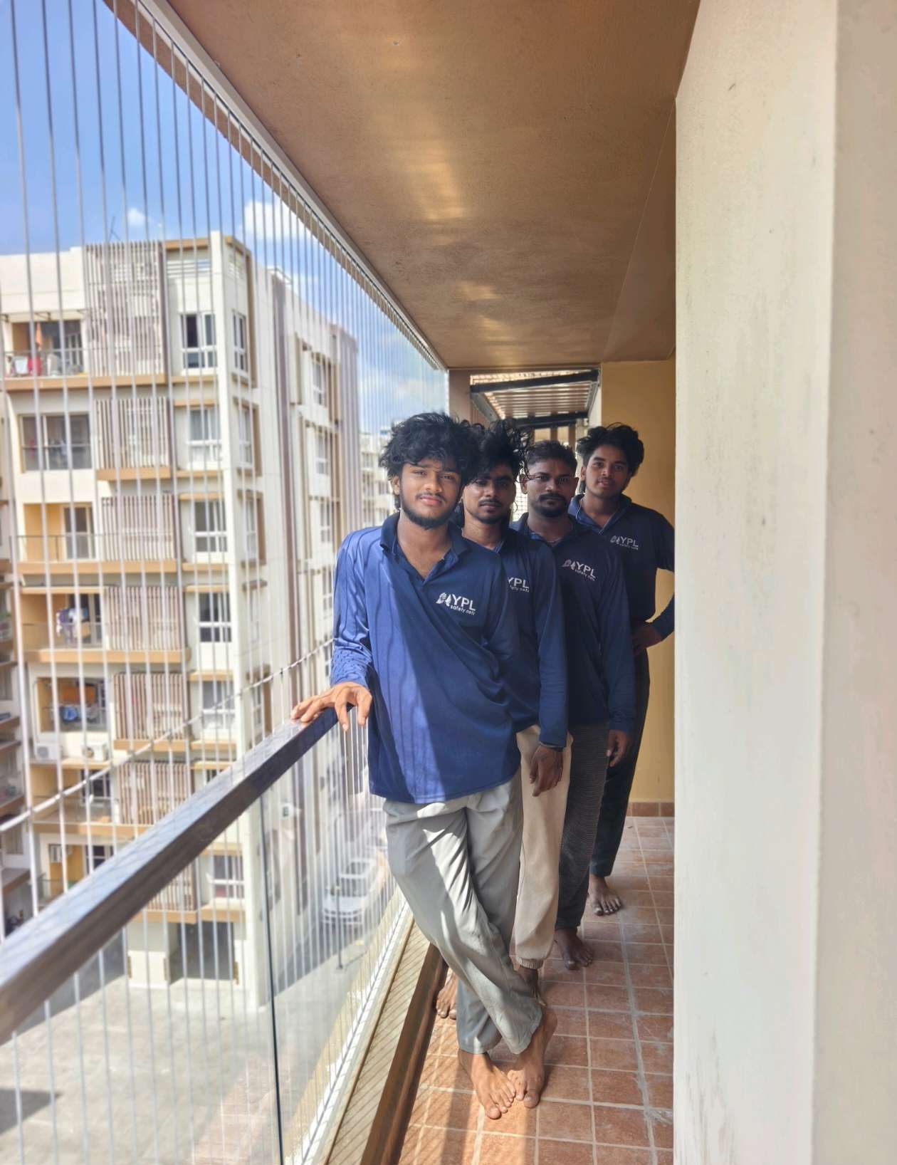 Installers working along a narrow apartment balcony — real YPL work shown for Uthandi customers