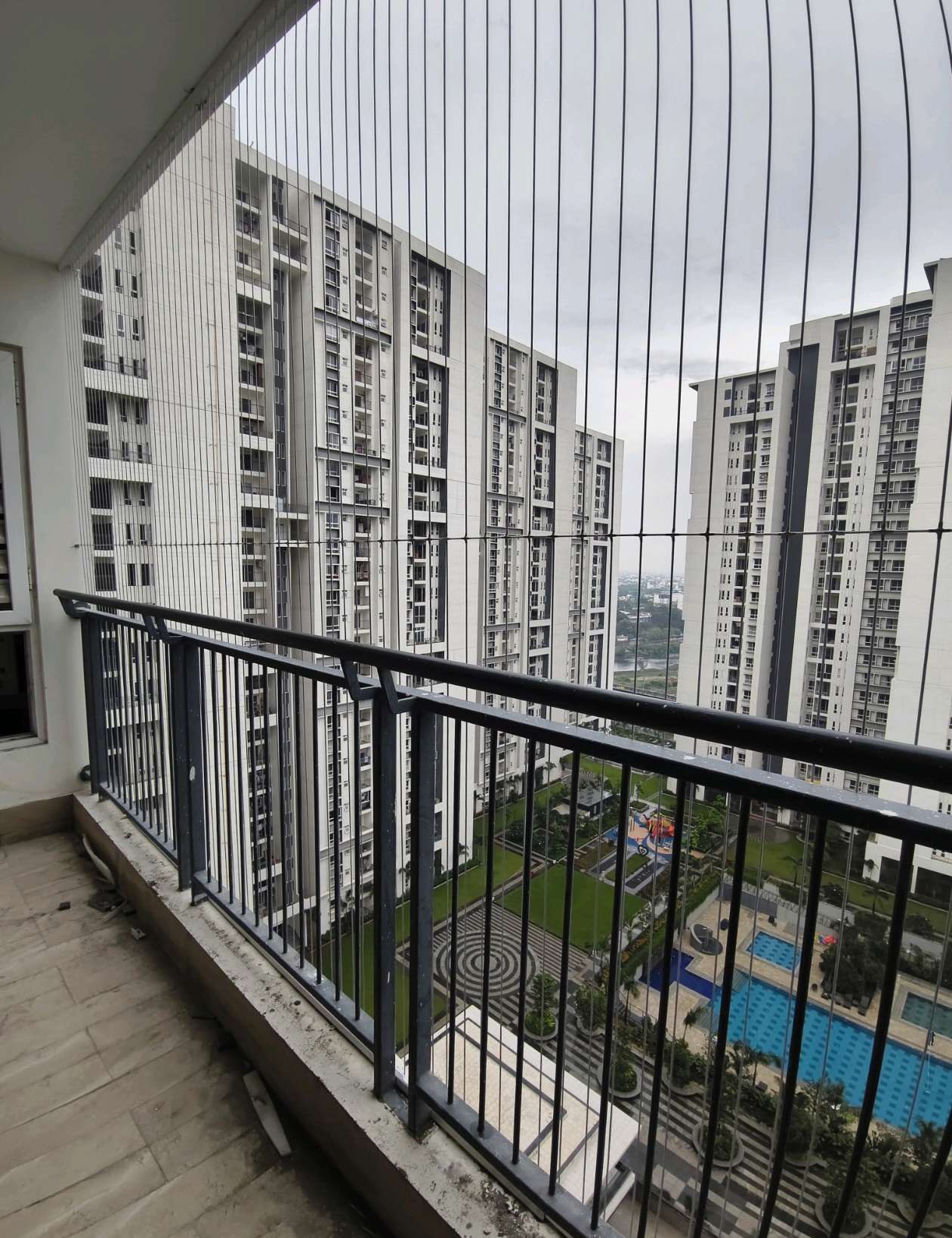 High-rise balcony corner overlooking an apartment courtyard — real YPL work shown for Puzhal customers