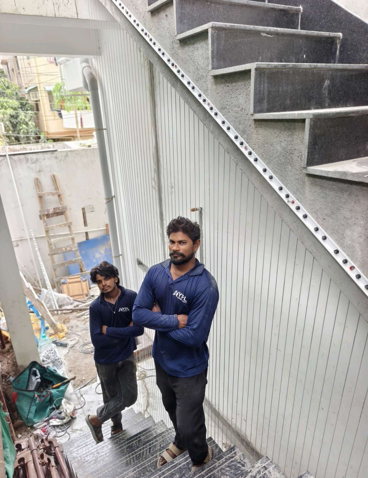 Workers fitting grill cables along an outdoor staircase — real YPL work shown for Kundrathur customers