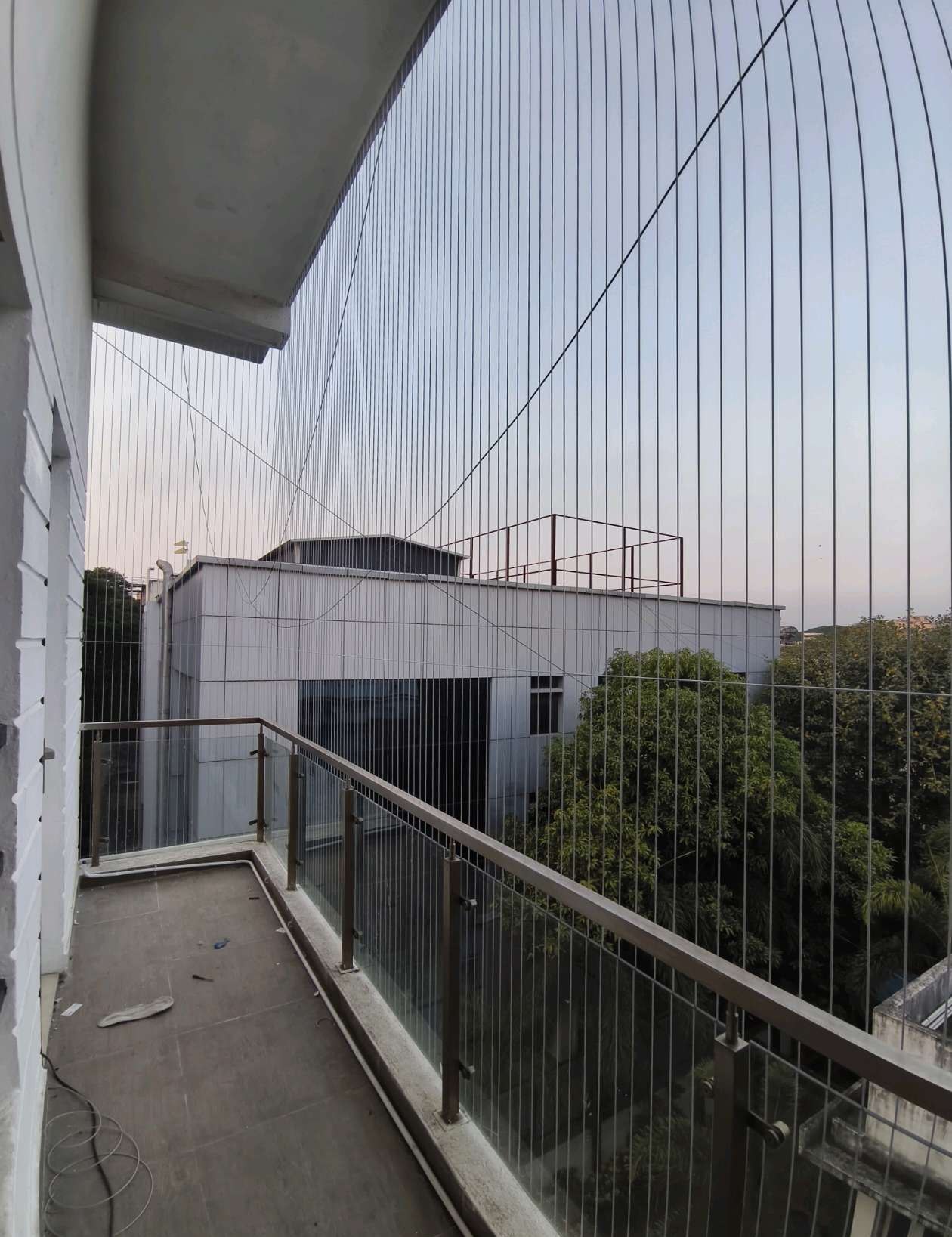 Balcony cables spanning a corner above a railing — real YPL work shown for Uthandi customers