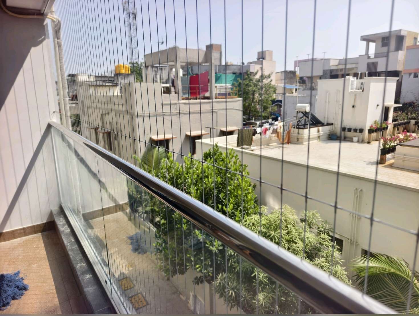 இன்விசிபிள் கிரில் சதுர அடி விலை – Residential balcony with grill cables above a glass railing